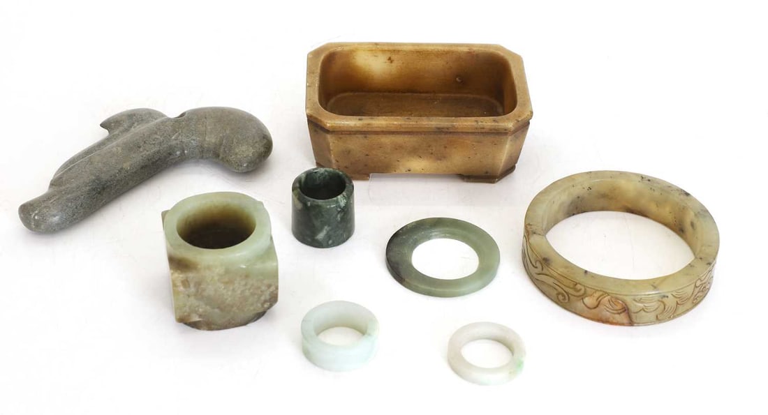 A collection of Chinese jade and hardstone,: A collection of Chinese jade and hardstone, each of archaic form, comprising: a carved jade bangle, an archer's ring, a cong with a square outer section around an inner circular hole, a dragon pendant