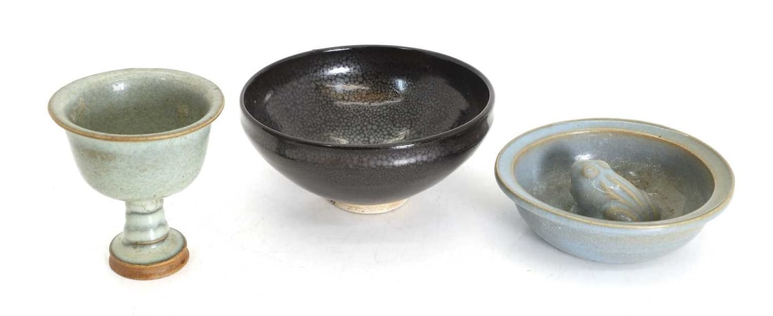 Three Chinese ceramics,: Three Chinese ceramics, comprising: a celadon-glazed stem cup of circular form rising from a splayed foot, and a crackle-glazed bowl with an applied frog to the centre, and a Jian-ware 'oil spot' bowl