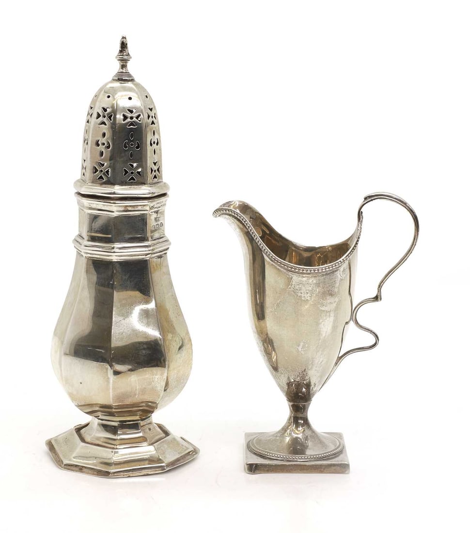 A George III silver helmet shaped cream jug,: A George III silver helmet shaped cream jug, and a silver castor, Birmingham, 1926, marks worn 13,5cm and 20.5cm high, 11.9ozt overall 2 Condition Report: Cream jug - worn. Dents to the castor.