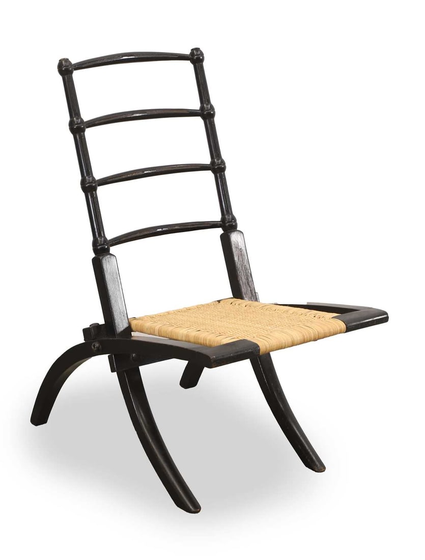 An Aesthetic ebonised folding low chair, late 19th century, in the manner of EW Godwin,: An Aesthetic ebonised folding low chair, late 19th century, in the manner of EW Godwin, with a rush seat 37cm wide, 74cm high