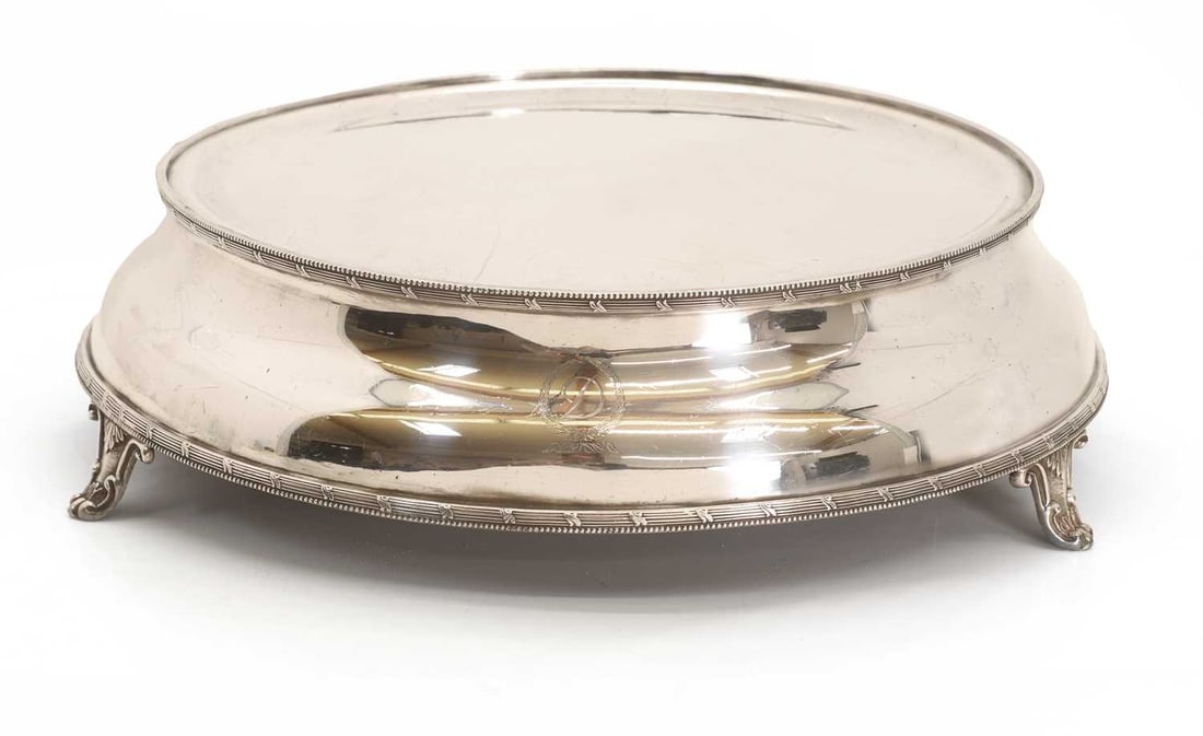A silver plated cake stand,: A silver plated cake stand, circular, engraved with 'D' within a wreath