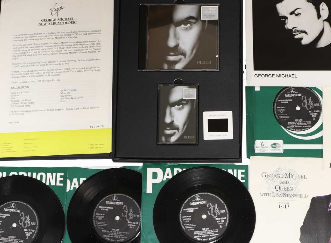 A presentation box, launching the album 'Older' by Virgin Records, May 1996,: A presentation box, launching the album 'Older' by Virgin Records, May 1996, the cloth-bound folder containing a CD, a tape, a photographic slide, two black and white photographs, a biography and a tr