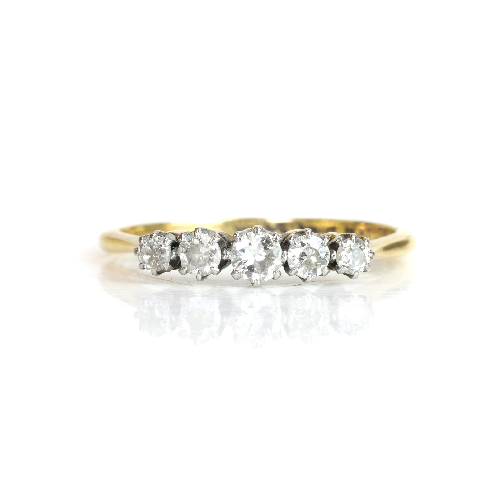 A diamond five stone ring,: A diamond five stone ring, claw set in white with a line of graduated old European cut diamonds and a central round brilliant cut diamond, to a yellow under bezel, tapered shoulders, and a 'D' profile