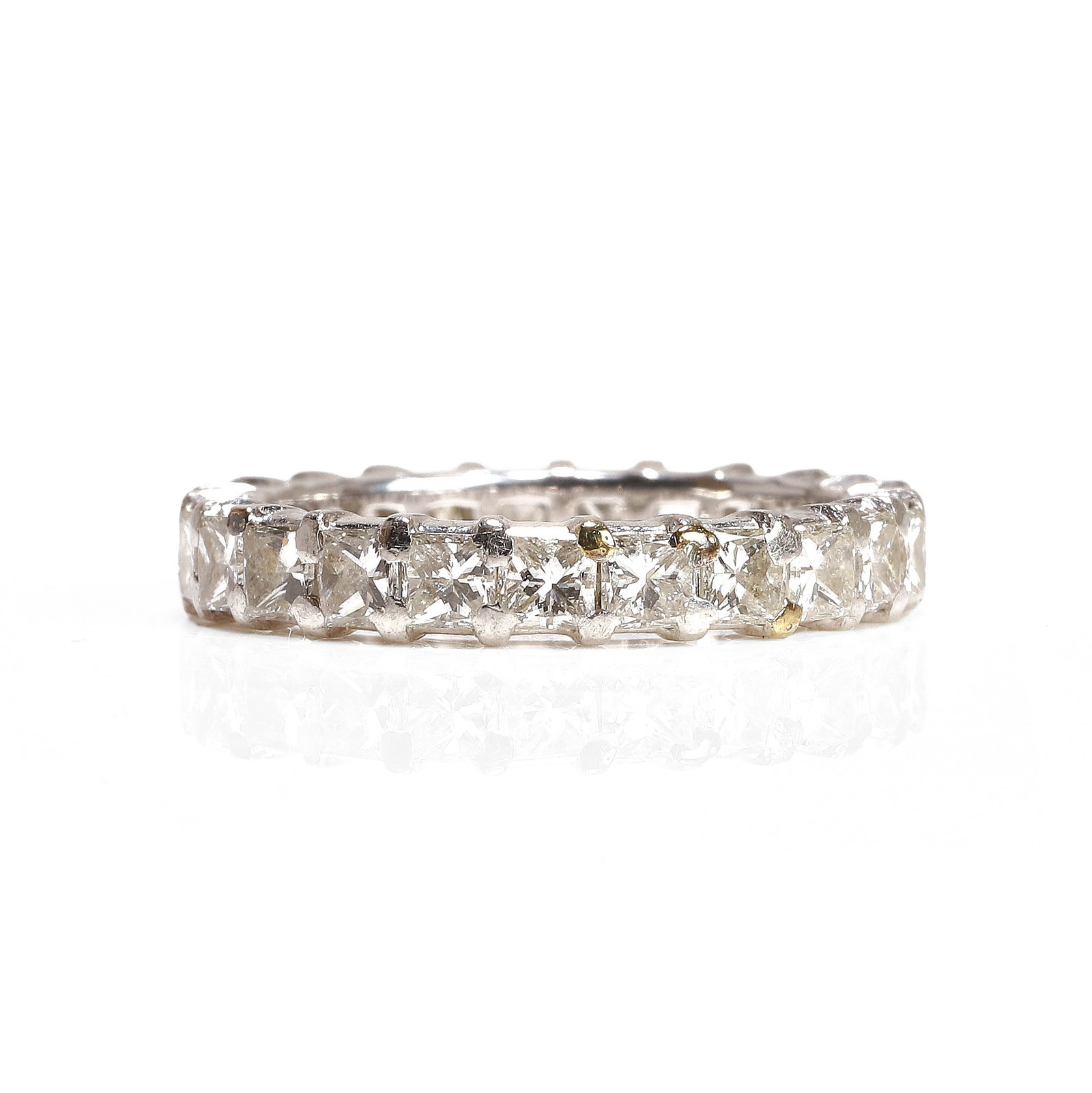 A princess cut diamond eternity ring,: A princess cut diamond eternity ring, claw set with a line of princess cut diamonds, one stone deficient, stamped Pt 950, total diamond weight approximately 2.00ct (Ring size KΩ; 4.7g) Footnote: