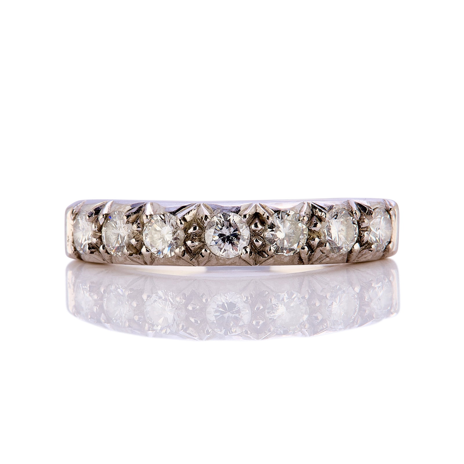 An 18ct white gold half eternity ring,: An 18ct white gold half eternity ring, set with seven brilliant cut diamonds totalling approximately 0.56ct, hallmarked London 1983 (Ring size M; 4.4g) Footnote: Buying this diamond ring at auction
