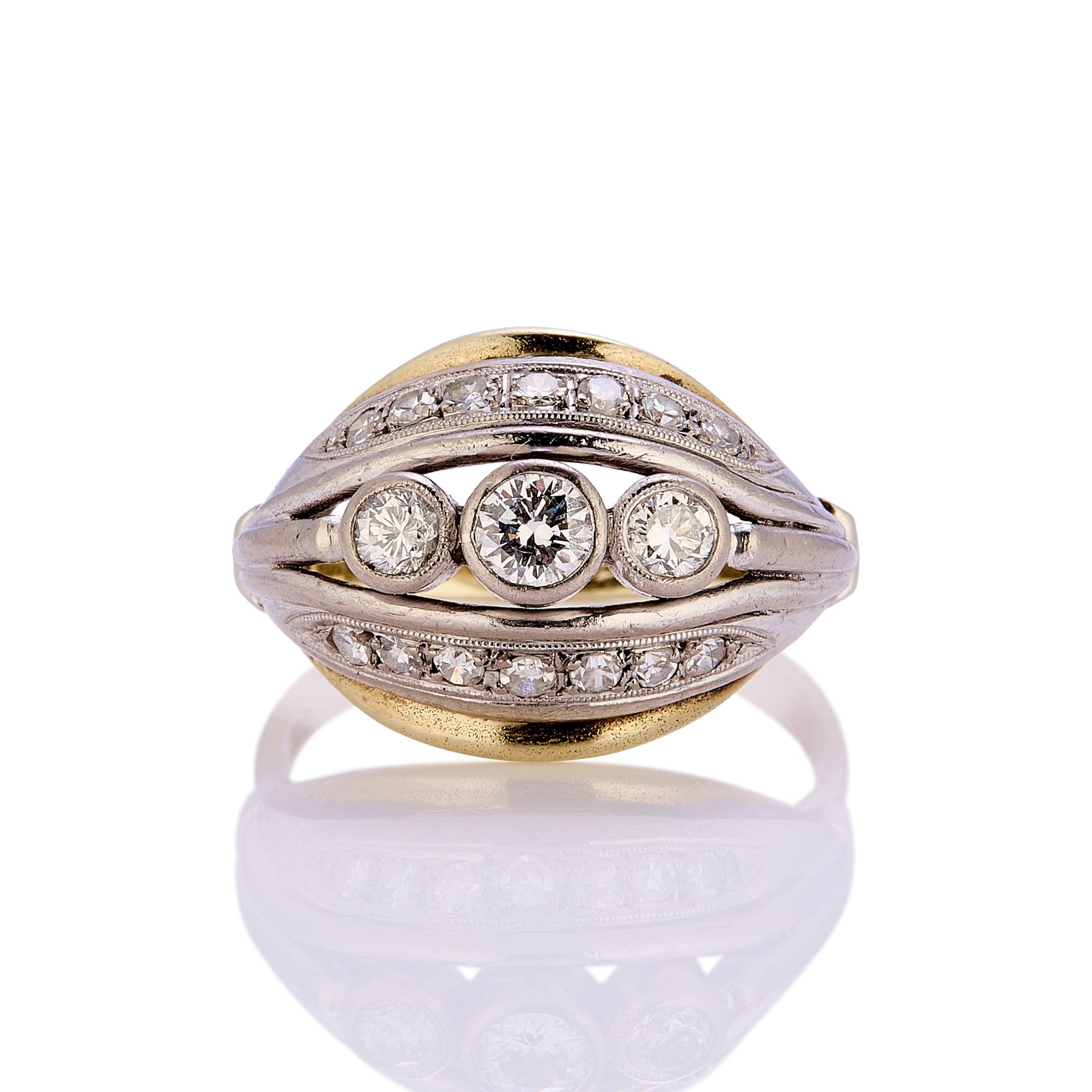 A three stone diamond bomb? ring,: A three stone diamond bombÈ ring, composed of three graduated round brilliant cut diamonds in millegrain setting, with thread and grain set single cut diamonds mounted in white bands above and