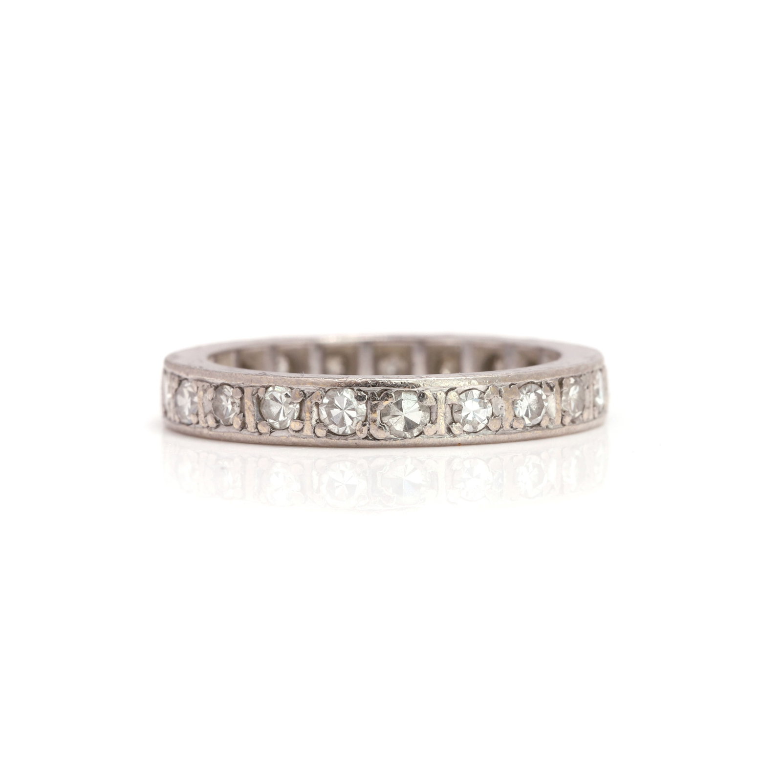 A diamond eternity ring,: A diamond eternity ring, grain set with single cut diamonds, to engraved sides, total diamond weight estimated as 0.63ct, tested as platinum (Ring size Iæ; 4.0g) Footnote: Buying this diamond