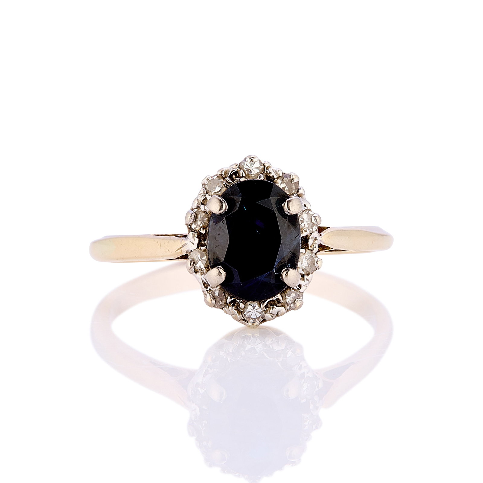 An 18ct gold sapphire and diamond cluster ring,: An 18ct gold sapphire and diamond cluster ring, claw set with a central oval sapphire and a surround of ten, single cut diamonds to a tapered band, unmarked, tested as approximately 18ct gold (Ring si