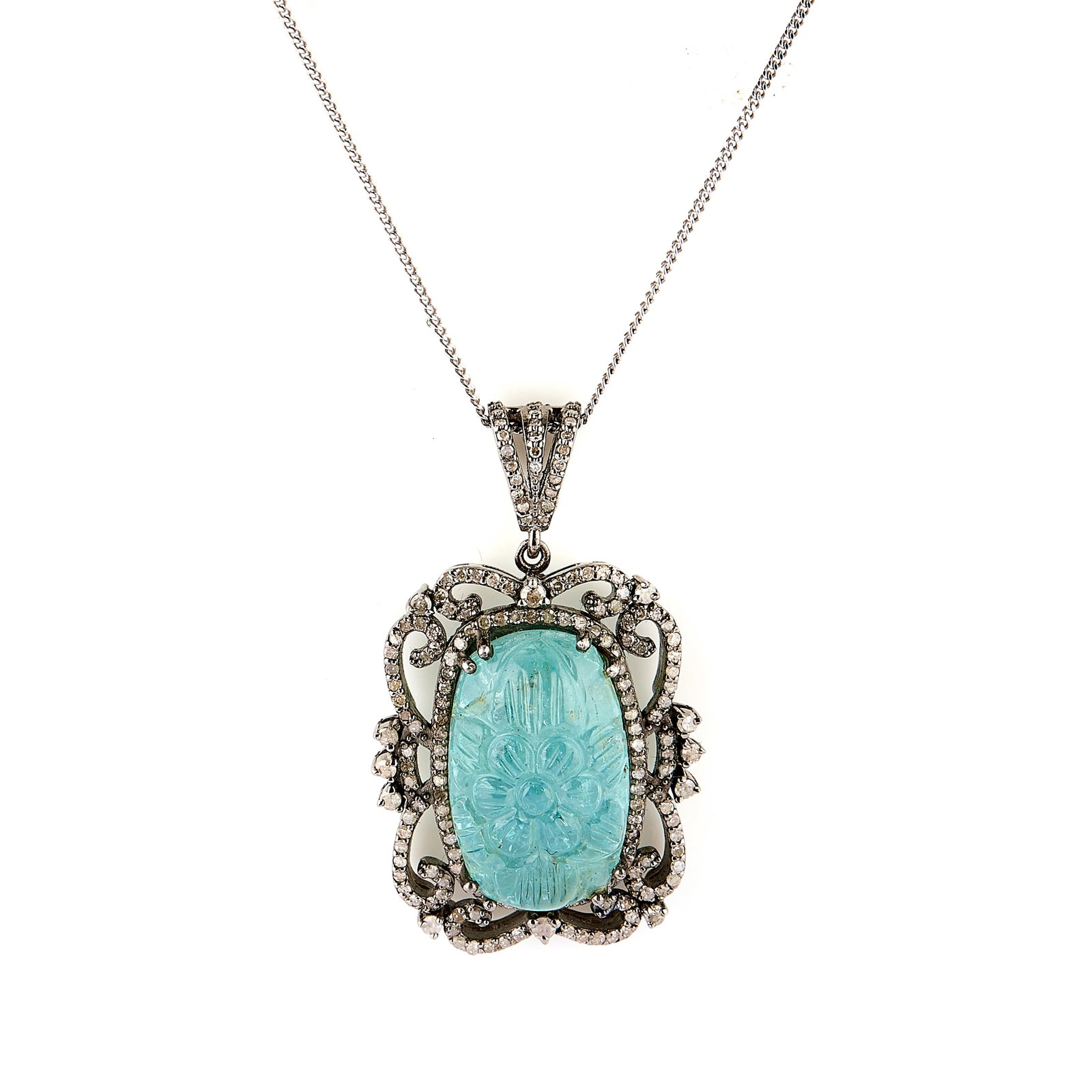A carved aquamarine and diamond pendant necklace,: A carved aquamarine and diamond pendant necklace, the cushion shaped aquamarine, carved with a floral motif, within a diamond-set scrollwork mount, suspended from a fine curb link chain, all stamped
