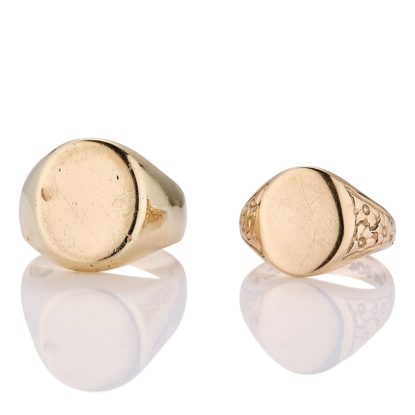 Two 9ct gold signet rings,: Two 9ct gold signet rings, one with vacant oval head, hallmarked London 375 1964, and one with vacant oval head with incised floral detail to shoulder, hallmarked Sheffield 375 1966 (18.36g) (2)