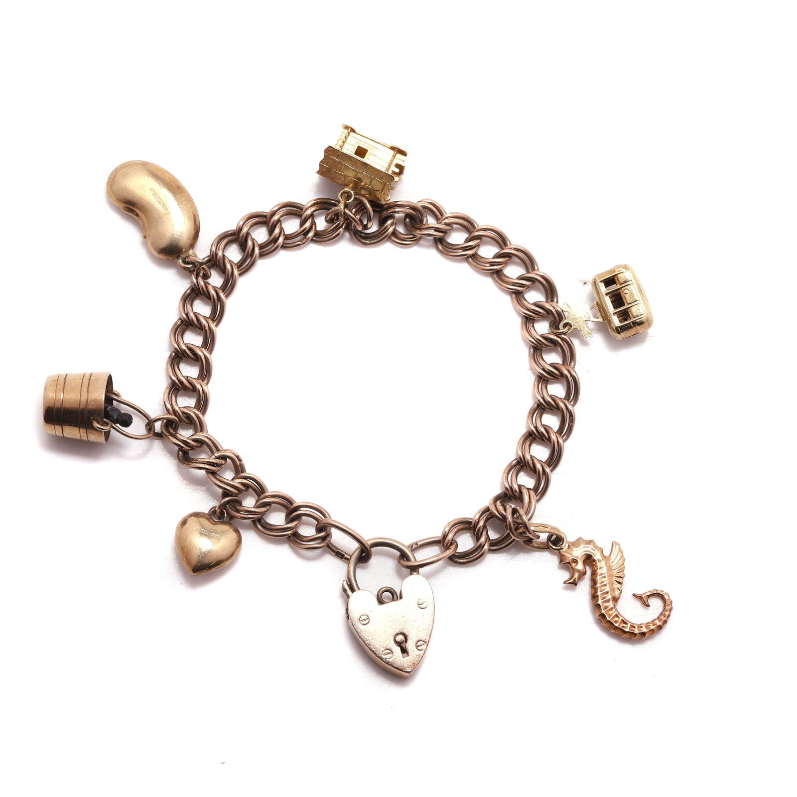 A silver gilt bracelet suspending gold charms,: A silver gilt bracelet suspending gold charms, with heart shaped locket clasp hallmarked London, silver, with seahorse and chalet charms hallmarked 18ct gold, and a cable car, coffee bean, bucket and