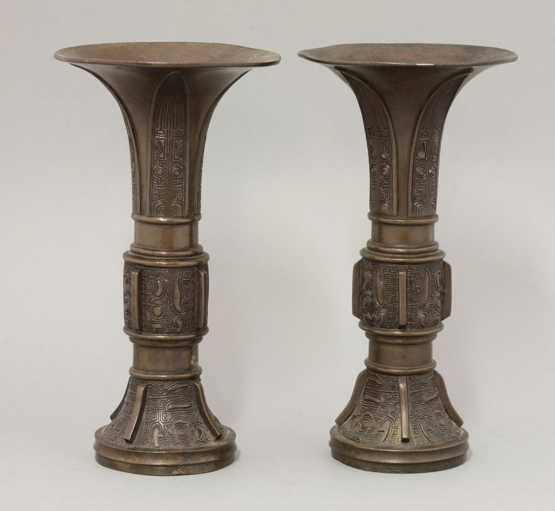 A pair of bronze Gu, c.1900, in Shang style, each: A pair of bronze Gu, c.1900, in Shang style, each typically decorated with cast archaic panels, 22cm (2)