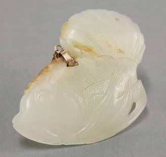 A Chinese jade Pendant, 18th/19th century, carved in: A Chinese jade Pendant, 18th/19th century, carved in the form of a fish with big fan-like tail, the stone of pale celadon tone with gold clasp, 6.2cm long Formerly in an English private collection, pu