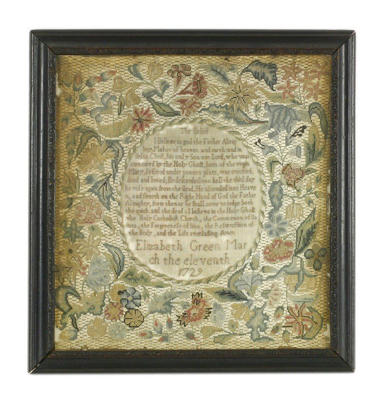 A needlework sampler, early 18th century, embroidered: A needlework sampler, early 18th century, embroidered with 'The Belief' or Creed, within a foliate border, by 'Elizabeth Green, March the Eleventh 1729', 32.5 x 30cm, in the original carved ebonised f