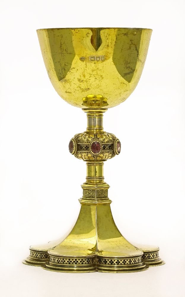 A Victorian Gothic Revival silver gilt chalice,by Carl: A Victorian Gothic Revival silver gilt chalice,by Carl Krall, London 1893, also stamped Krall in a rectangular shield, the plain tapering circular bowl above a knopped column stem, the knop with folia