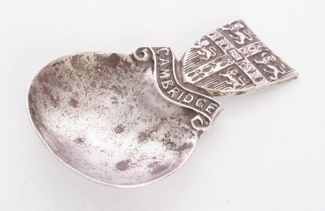 A silver souvenir caddy spoon, by Bernard Instone,: A silver souvenir caddy spoon, by Bernard Instone, Birmingham 1930, with a circular hammered bowl, the shield-shaped handle bearing the arms of the University of Cambridge, inscribed 'Cambridge' below