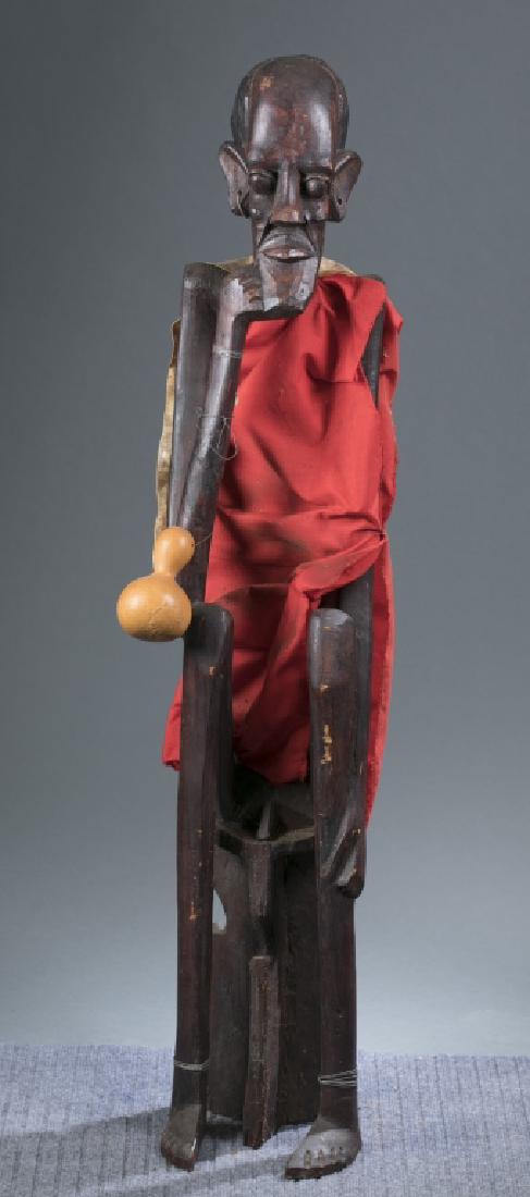 Contemporary African sculpture of a seated male. (1 of 3)