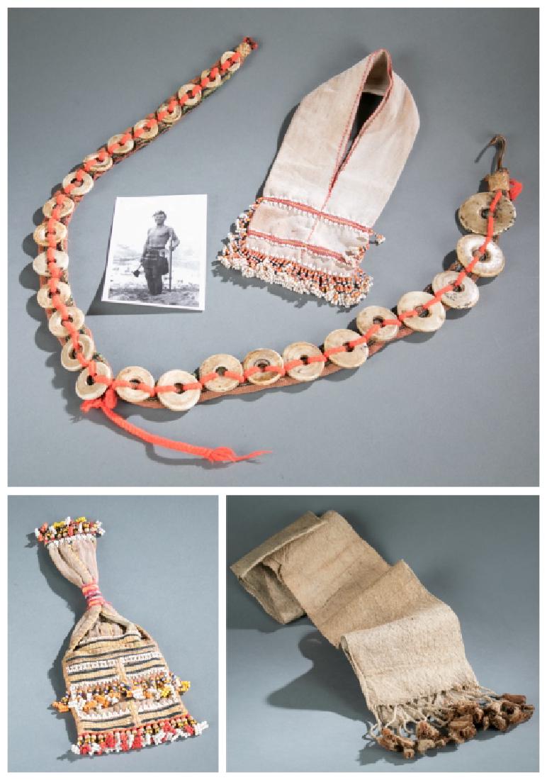 3 ethnographic necklaces / sashes. 20th cen.: A group of body decoration. ++ Shell necklace and sash. Largest: 45"h x 2 3/8"w x 1/8"d.++Sash. Folded in half: 51"h x 7 1/4"w x 1/8"d.++Beaded bag. 11"h x 5"w x 1/2"d. Provenance: Collection of John