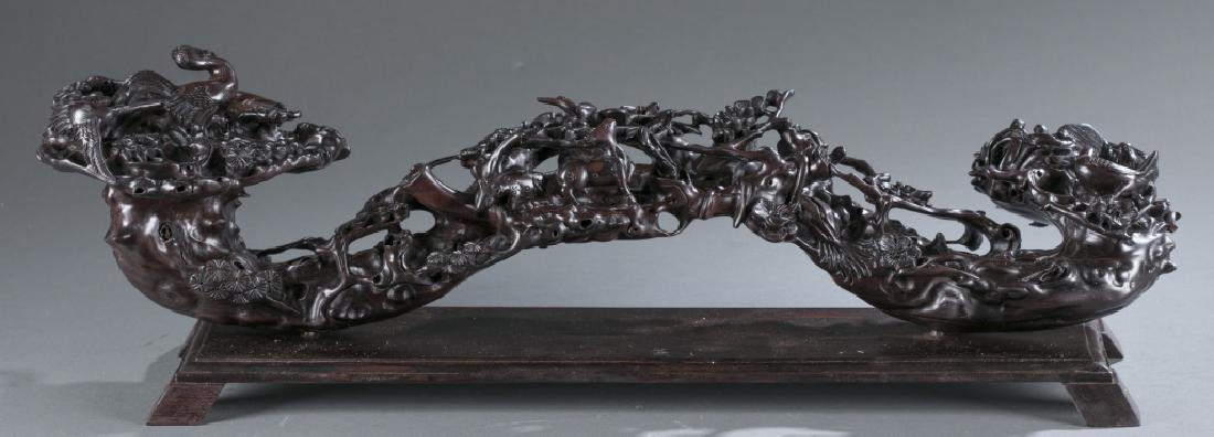 A Chinese carved hardwood ruyi.: A Chinese carved hardwood ruyi. 20th century. Intricately carved with birds, cranes, and squirrels amongst foliage design. 25"l.