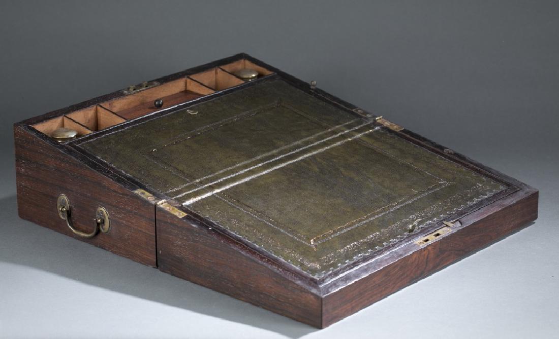 Rosewood lap desk or writing box.: A Rosewood lap writing box. 19th century, Writing surface with tooled green leather surface opening to reveal storage areas. Brass escutcheon, handles and plaque on the lid. I believe there is a drawe