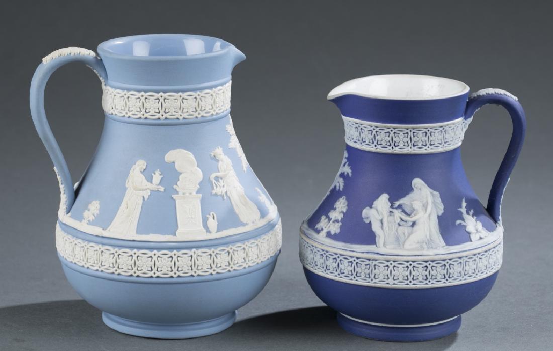 2 Wedgwood jasperware Etruscan jugs. c. Late 19th: A group of two Wedgwood jasperware Etruscan jugs in medium. ++ Medium Etruscan jug in pale blue and white. 1971. 5 1/2" x 4". ++ Medium Etruscan jug in dark blue in white. 1891-1897. 5" x 5 1/2". Prov
