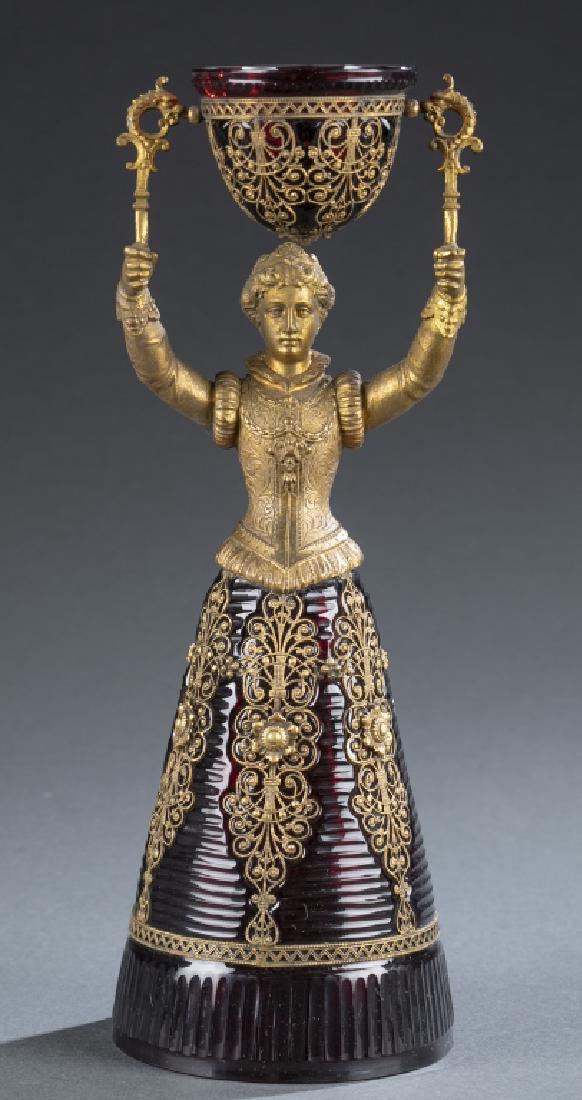 Bohemian Fritz Heckert style cranberry wedding cup: A Bohemian Fritz Heckert style cranberry wedding cup with red glass and gold-colored detail.