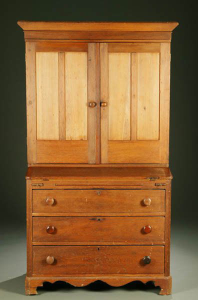 American pine desk and bookcase. 19th century.: American pine desk and bookcase. c.1880. Upper case having a cornice over two paneled doors enclosing three shelves, row of pigeonholes, and two short drawers, above lower case with felt-lined fold-ou