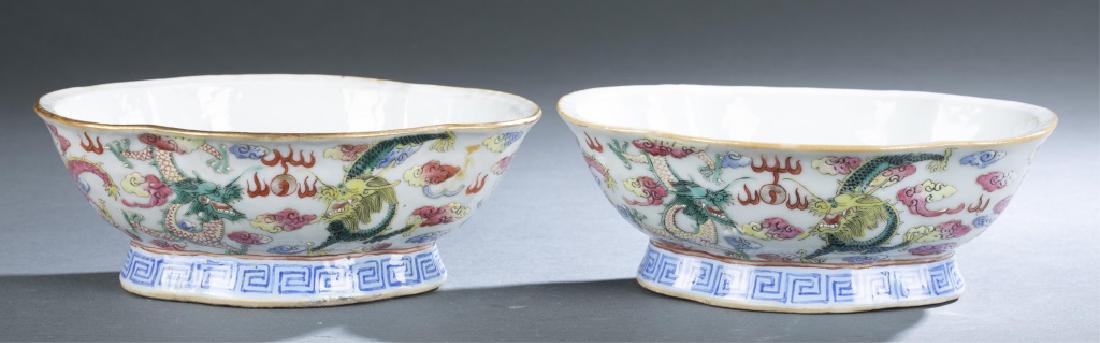 Pair Chinese famille rose porcelain bowls.: A pair of Chinese famille rose porcelain bowls. Late Qing dynasty. Haitang Wan form, footed bowl with scalloped rim. Painted with a design of dragons playing flaming pearl flying through clouds. Six-c