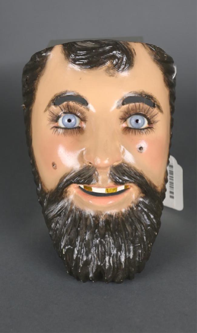 Mexican Folk Art Bearded Mask, 20th/21st century.: A Mexican Folk Art Bearded Mask. 20th/21st century. Polychrome painted plaster on wood with false eyelashes, glass eyes, curly beard, and gold foil covered teeth. No marks or signature. 9" x 6 1/2" x
