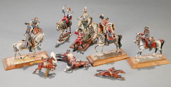 Group of handpainted lead figures, various makers: 10 mounted lead figures and horses. All have been fixed to a wooden base, obscuring the mark. The paint is in good condition, but many of the riders have lost their hoses, and there is some damage to