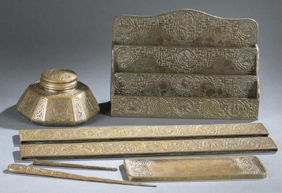 7 piece Tiffany Zodiac Bronze Desk Set.: A seven-piece Tiffany Studios Gilt Bronze Desk Set. circa 1900. Marked "Tiffany Studios New York." Includes large letter rack, pen (with out nib), pen tray, letter opener, blotter ends, stamp box, and