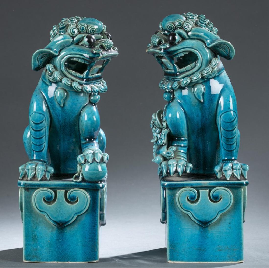Pair Chinese blue glaze porcelain Fu lions.: A pair of Chinese blue glaze porcelain Fu lions. 20th century. Peacock blue glaze. Depicting a pair of Fu lions on stand, one with brocade ball the other with cub. 12" x 5" x 6 1/2"._x000D_ Condition: