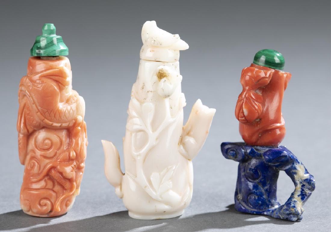 3 Coral snuff bottles.: A group of three small coral snuff bottles. ++ Carved coiled around a column, incised with cloud motifs, on flat base, with malachite stopper. 1 7/8â€h. ++ Small coral carved in a fruit form, resti