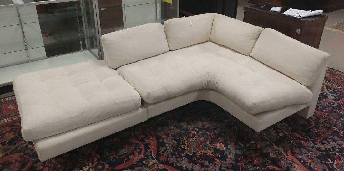 Vladimir Kagan, Omnibus sectional sofa.: A Vladimir Kagan (American, 1927-2016), Omnibus sectional sofa. Two seat sectional together with an ottoman on lucite base. Label underneath sectional. Yellowing wear to white upholstery consistent wi