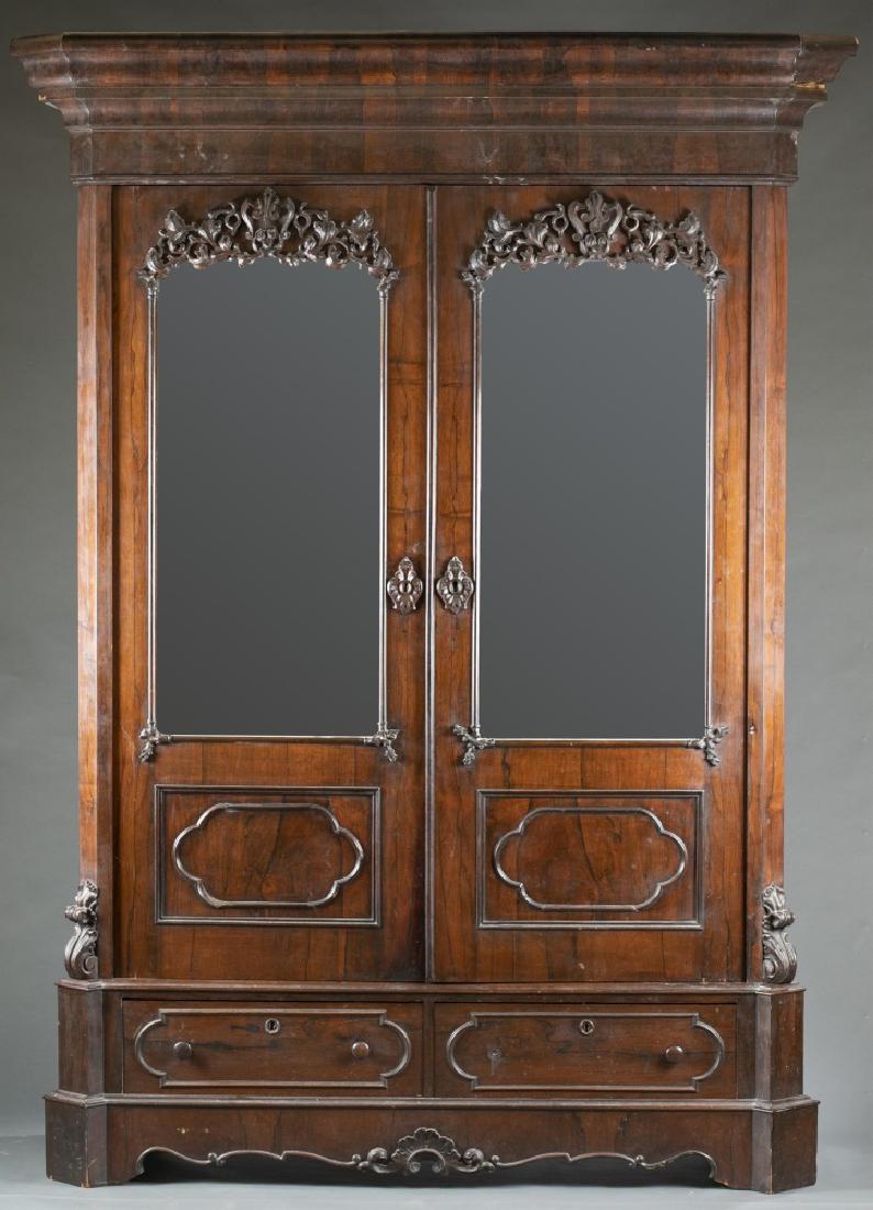 Empire/Victorian, transitional wardrobe, c. 1840.: An Empire/Victorian transitional wardrobe. Circa 1840. Carved mahogany, decorative scrolling and floral. Ogee cornice. Mirror double-doors over two bottom drawers. Wear consistent with age and use. To