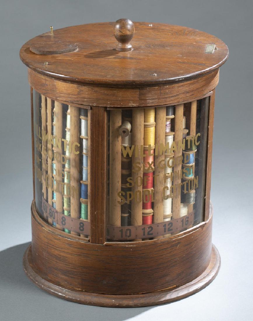Willimantic, round spool cabinet, 1897.: A Willimantic round spool cabinet. Willimantic, Maine. 1897. Oak body with glass panels. Six cord cotton, round spool storage cabinet. Rotating cylinder. Marked on plaque on top. Marked on glass. Wear