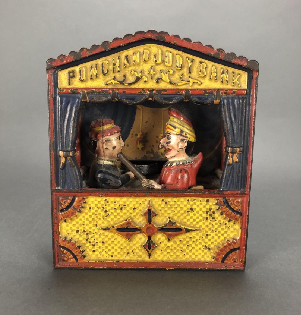 Punch & Judy, cast iron mechanical bank, ca 1884.: A Punch and Judy cast iron mechanical bank. Possibly Buffalo, New York. Circa 1884. Puppet theater with two characters with mechanical arms, one that punches, one that pushes coins into bank. Paint lo