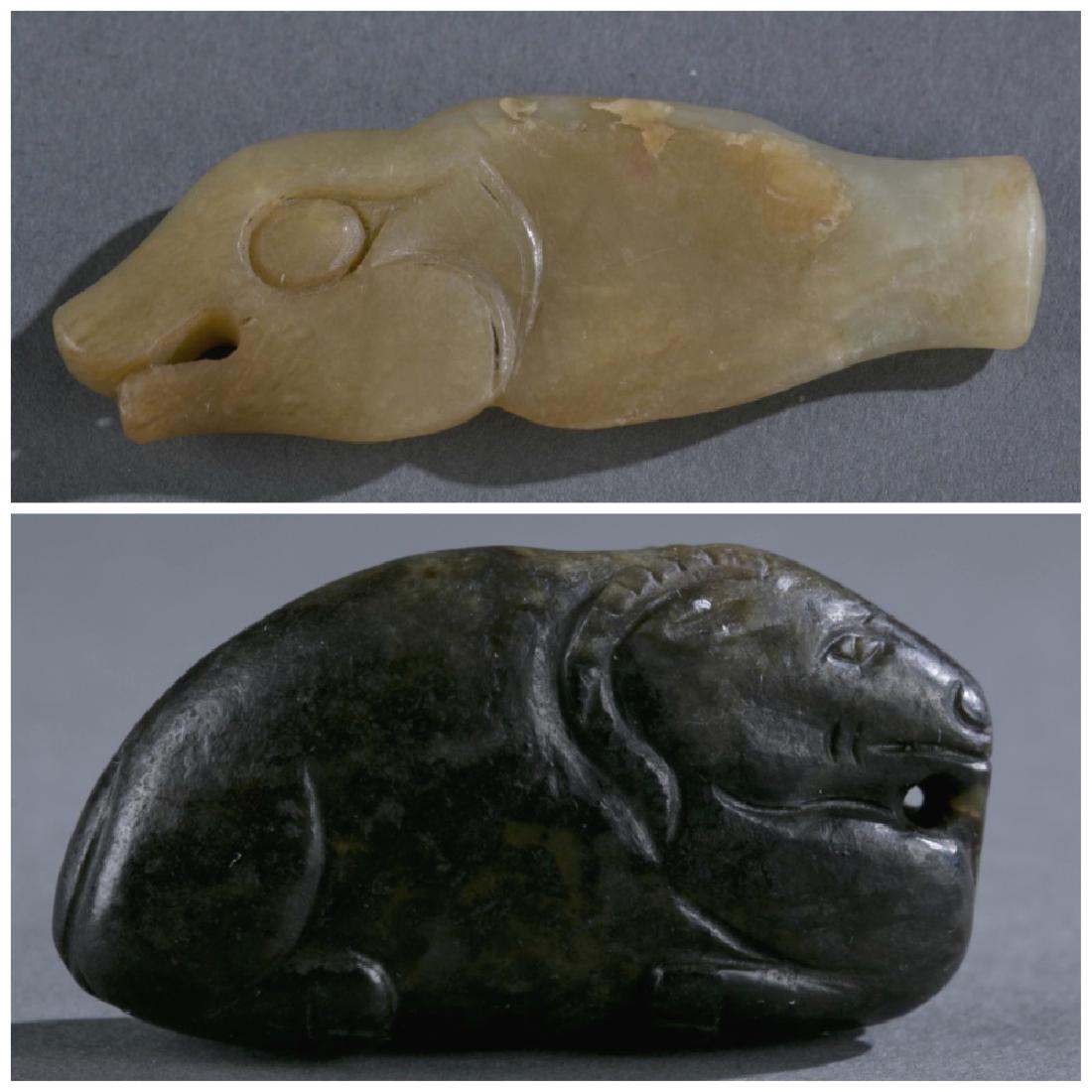 2 Archaic jade pendants.: A group of two archaic jade pendants. ++ A tan archaic jade fish pendant. Possibly Han dynasty. Abstract fish from, with phoenix-style eyes, pig-looking mouth, and short tail. 2 1/2". ++ A dark jade p