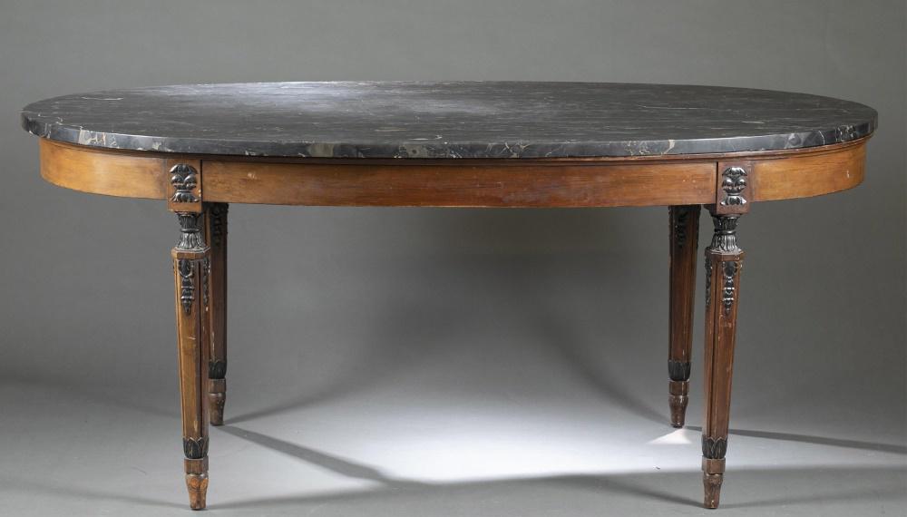 Louis XVI style, marble-top dining table.: A Louis XVI style, marble-top dining table. 19th century. Possibly French. Oval-shaped marble top on wooden frame. Oval-shaped framed with four legs black painted carved foliate and acanthus tapered l