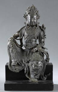 Bronze sculpture of Guanyin with stand.: A Bronze sculpture of Guanyin. Sculpture attached to stepped base. Seated with one leg up and one leg down, heavily adorned and wearing an elaborate headdress featuring the Buddha. Without base: 13 3/