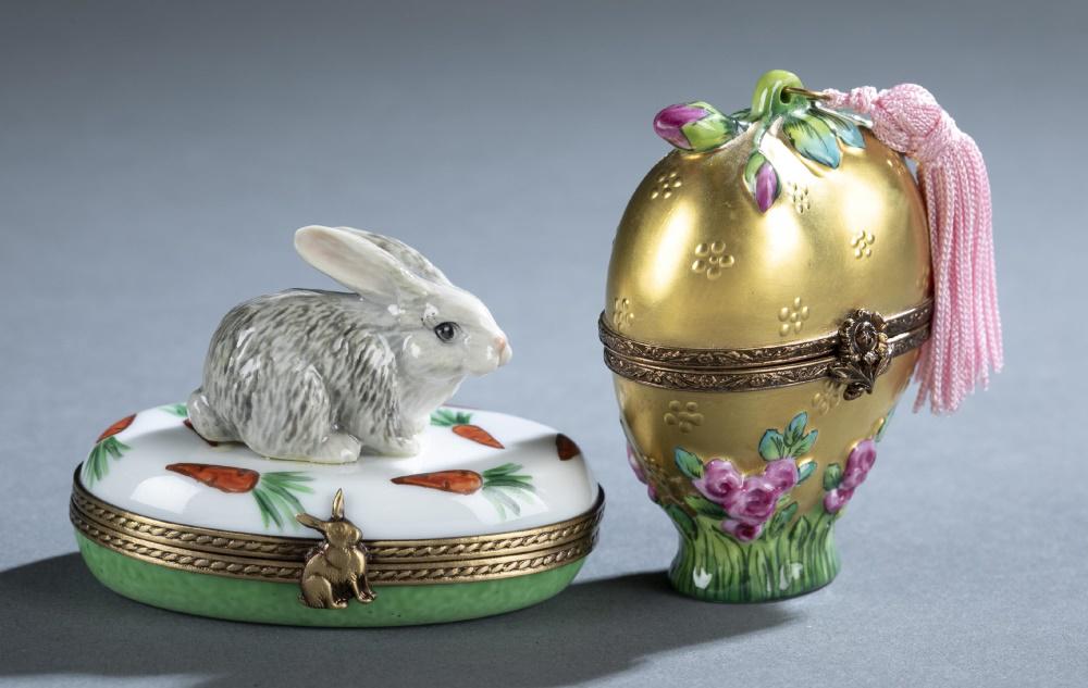 2 Limoges Peint Main, porcelain boxes, 20th c.: A group of two Limoges Peint Main porcelain boxes. 20th century. French. ++ Limoges Peint Main porcelain box. Gilt body with flowers on top (pink tassel) and along base. Interior contains glass heart-