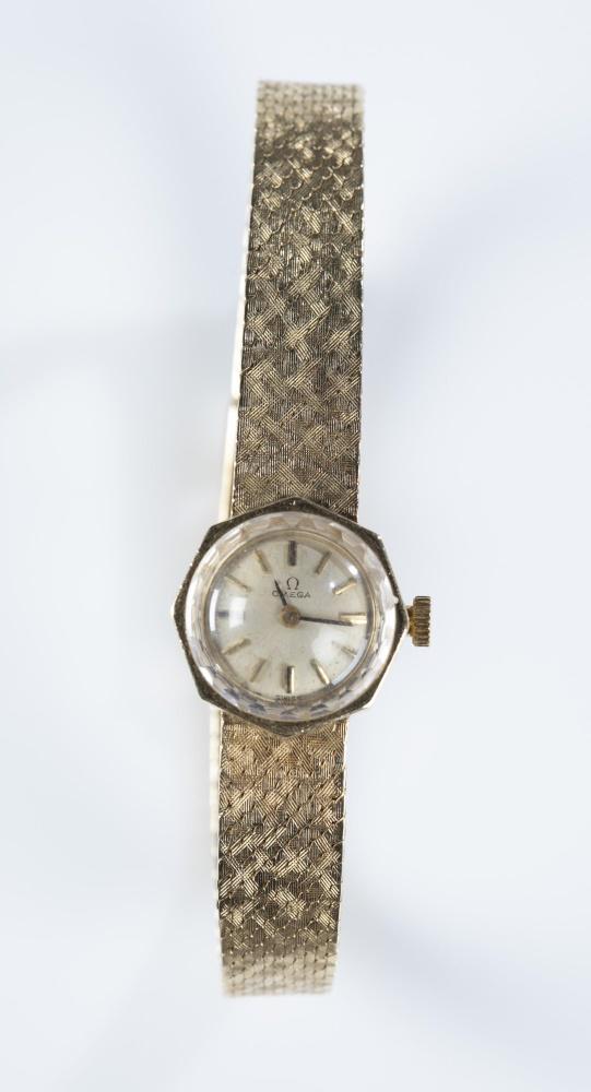 Ladies Omega 14k gold wind up wristwatch.: A ladies Omega 14k gold wrist watch. Round face with octagonal shaped 14k gold case and 14k gold band. Watch currently running. Diameter: 5/8".
