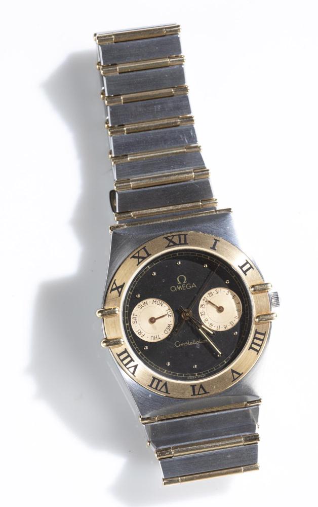 Omega Constellation 18k and stainless wristwatch: An Omega Constellation Quartz Day/Date Watch. Round face having a day dial and a date dial with stainless steel and 18k gold case. Band made of stainless steel and gold tone metal. Marked on face and 