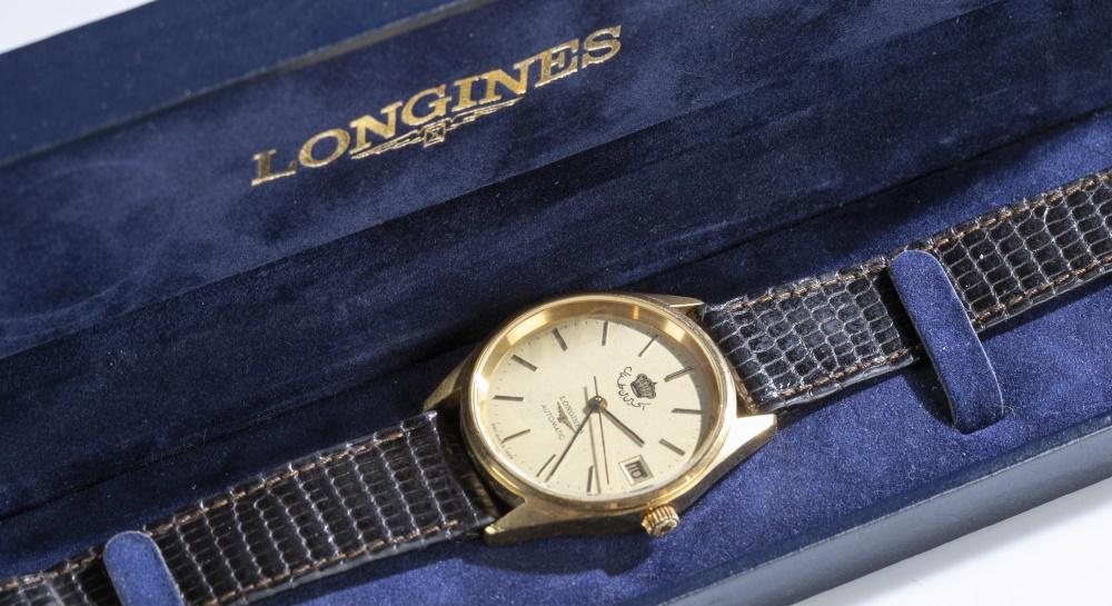 Longines King Hussein bin Talal wristwatch.: A Longines automatic wristwatch. Circa 1995. Round face with gold tone case. Emblem of King Hussein bin Talal from Jordan on watch face. Marked on face "Longines." Watch in working order. Blue Longine
