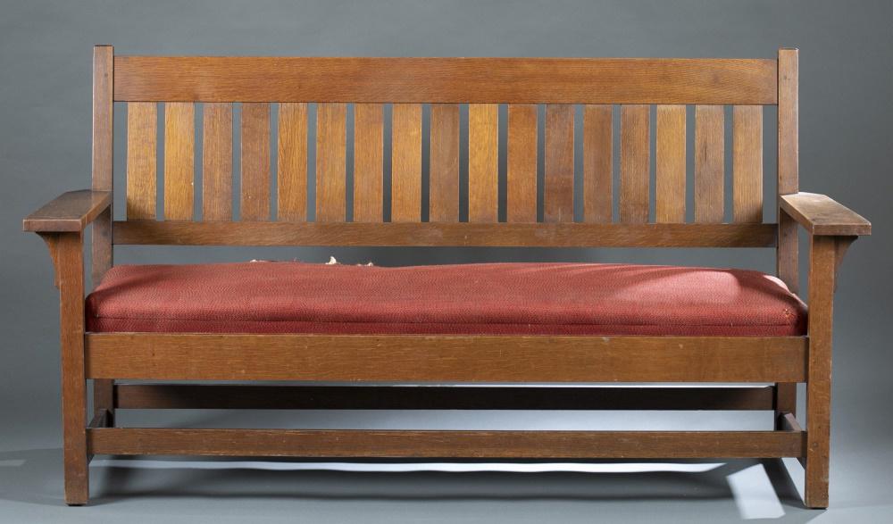 Gustav Stickley, oak settle #219.: A Gustav Stickley (American, 1858-1942) settle #219. Circa1912-1916.Oak constructed with slat back and open arms, with a russet colored upholstered seat. Marked with Craftsman Workshops brand lower le