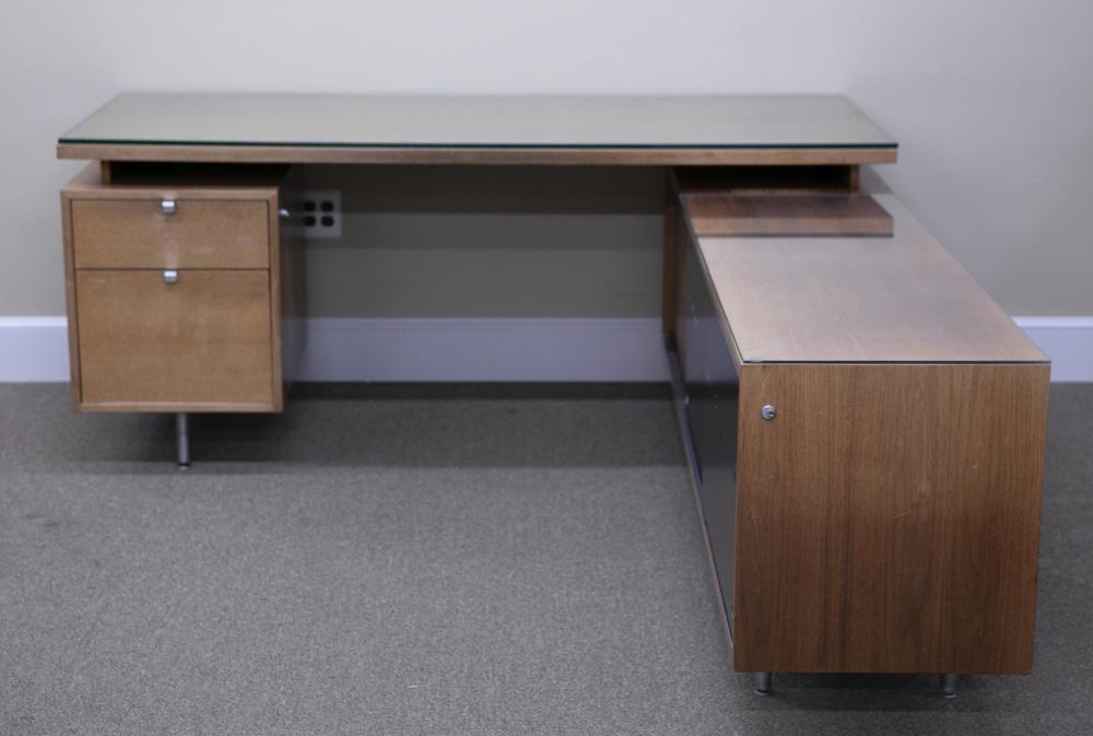 George Nelson for Herman Miller, executive desk.: A George Nelson (American, 1908-1986) for Herman Miller L-shaped executive desk. Zeeland, Michigan.1950's. Desk and attached credenza have walnut finish and protective glass panels. Metal hardware and