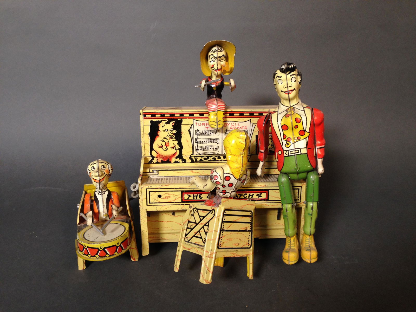 1940-50s Unique Art Tin Litho Li'l Dogpatch Band: 1940-50s Unique Art Tin Litho Wind up Li'l Dogpatch Band ++ Based off characters in comic strip by Al Capp ++ 9" x 10" x 7"_x000D_ Condition: Mechanism untested. Female piano bent out of place. Some s