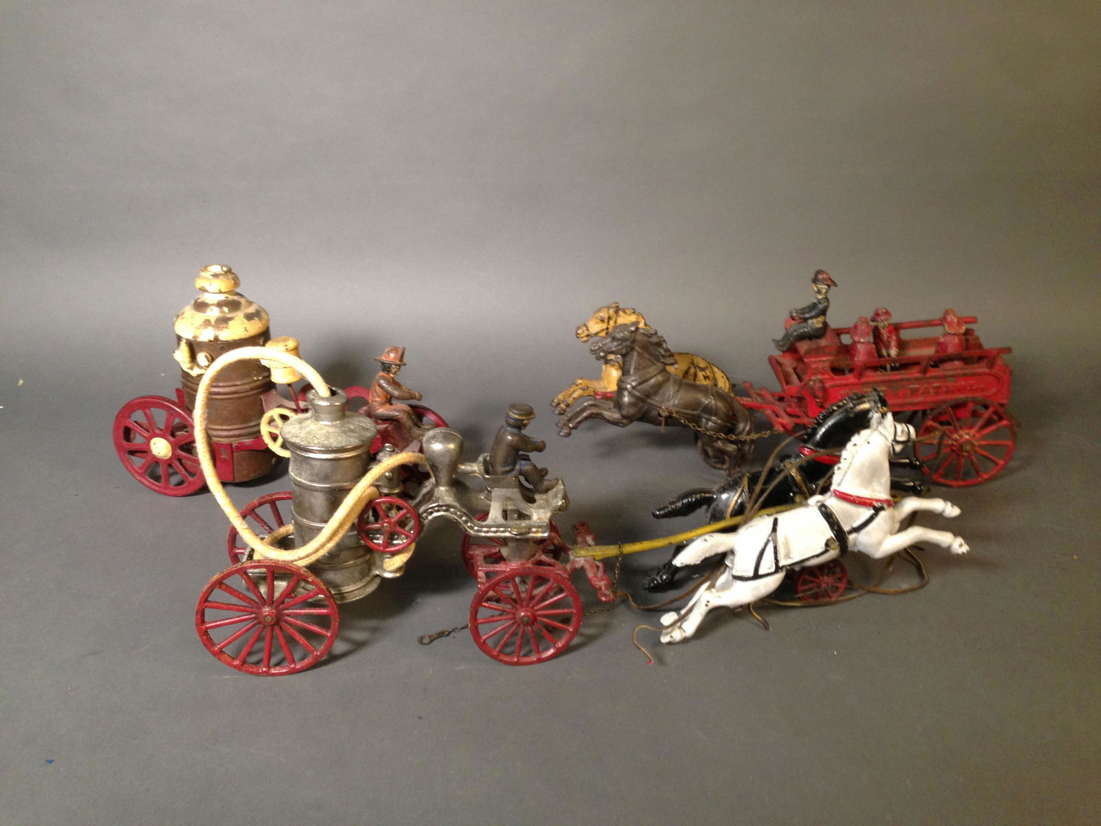 Three Cast Iron Horse Drawn Fire Engines: Three Cast Iron Horse Drawn Fire Engines ++ Two horse fire man cart with four figures, possibly Ives, 16" ++ Two horse fire pumper cart with one figure possibly reproduction, 20" long ++ Fire pumper c