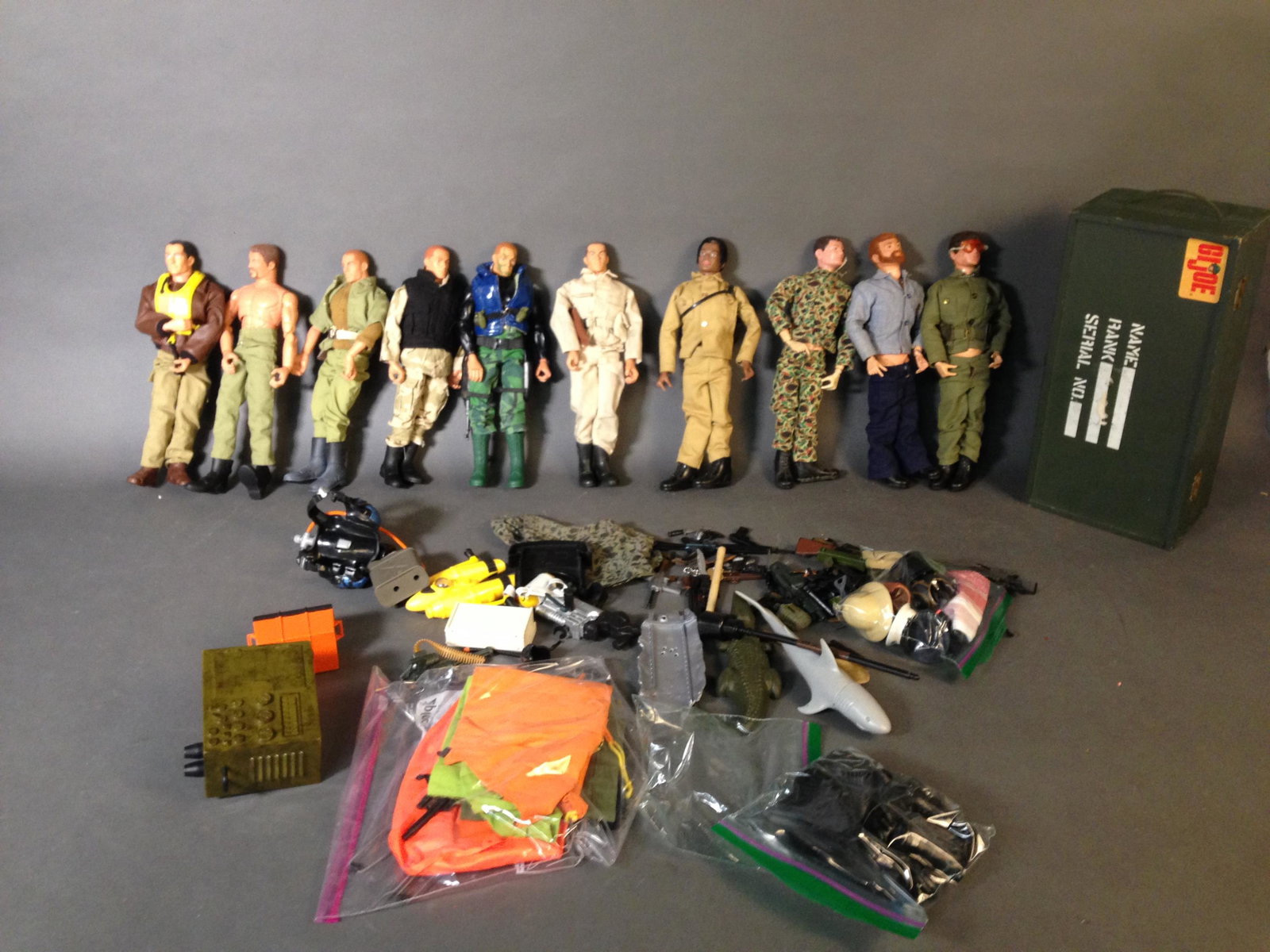 10 GI Joe 12" Figures, Accessories, & Footlocker: 10 GI Joe 12" Figures, Accessories, & Wooden Storage Footlocker Including four 1967-1975 GI Joe Figures ++ 1970s Sea Adventurer, 1970s Adventurer, 1960s Talking Marine, & 1970s Man of Action_x000D_ Co