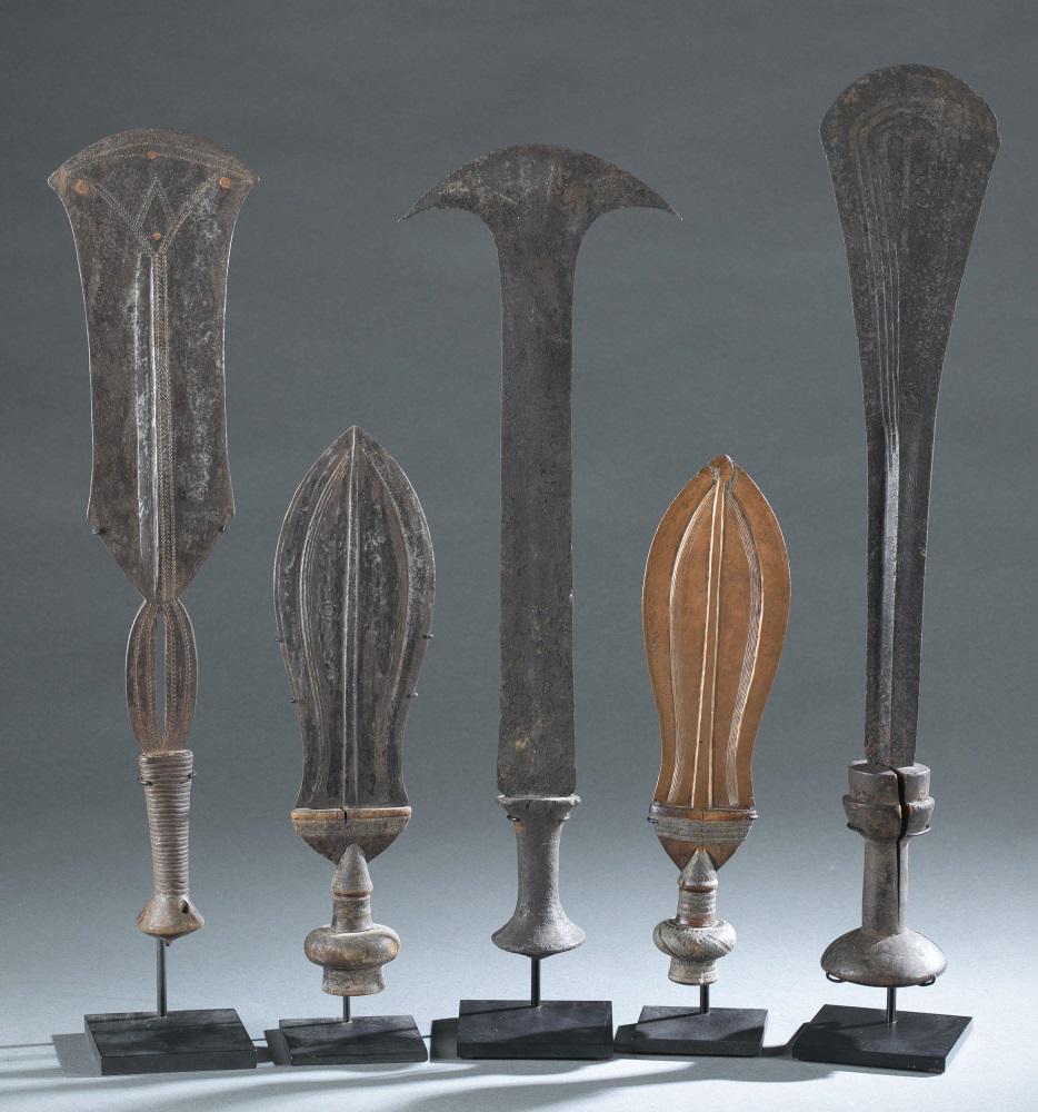 5 Central African Swords. Early 20th c.: A group of five Central African swords. Metal, wood. Early 20th century. ++ Yakoma sword. ++ Kuba knife. ++ Mongo knife. ++ Kuba knife. ++ Mongo sword. 23 1/4" x 4 1/2" x 3". Condition: May not includ